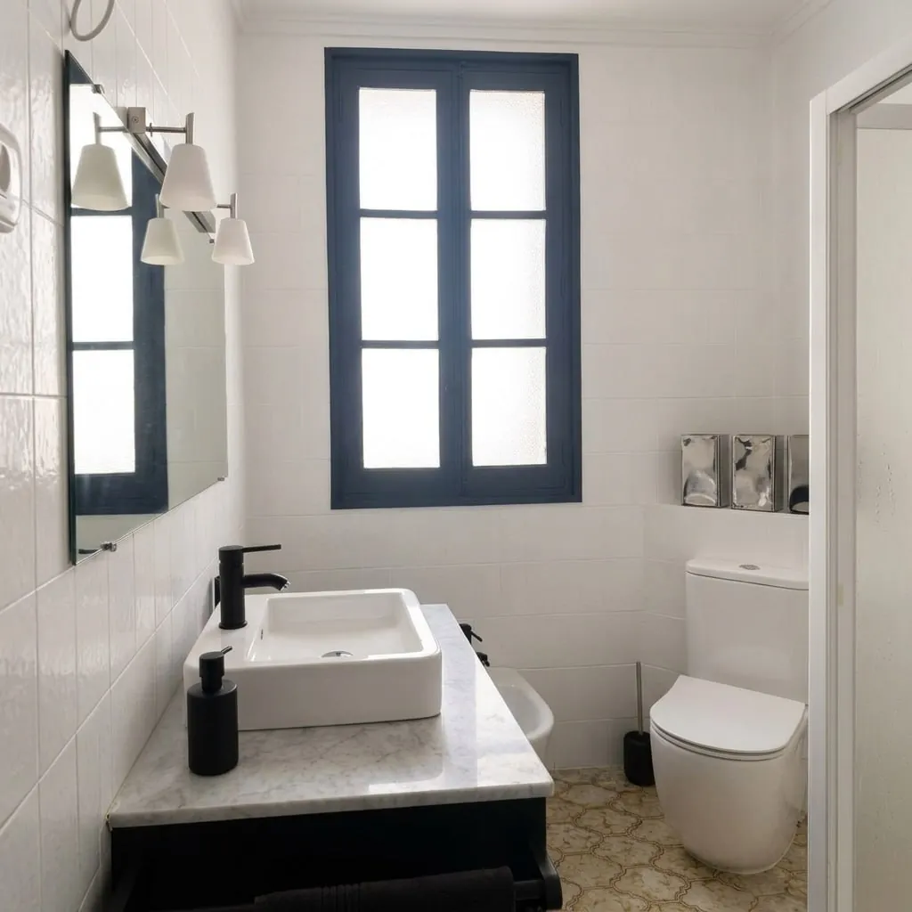 Baño con lavabo sobre encimera y ventana