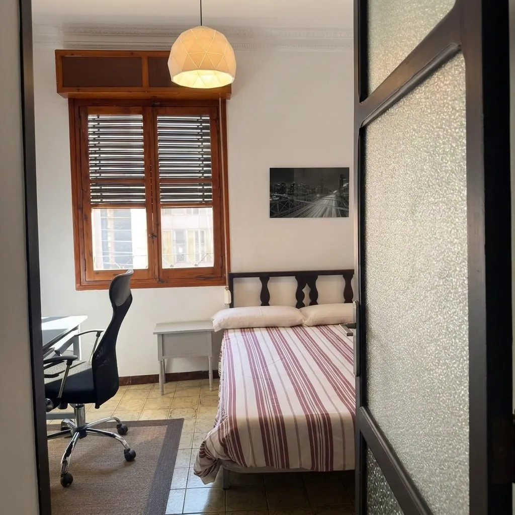 Dormitorio con escritorio junto a la ventana