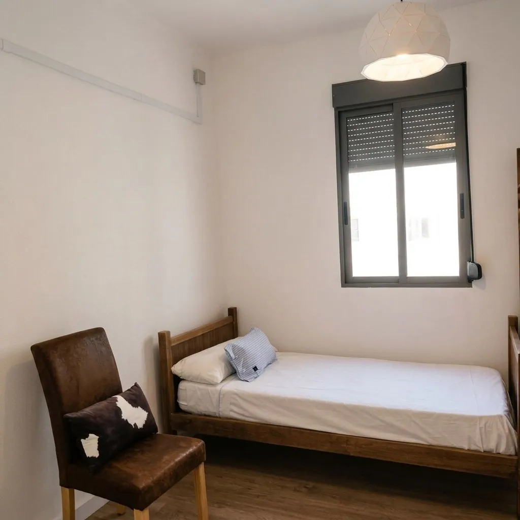 Dormitorio con cama individual y butaca
